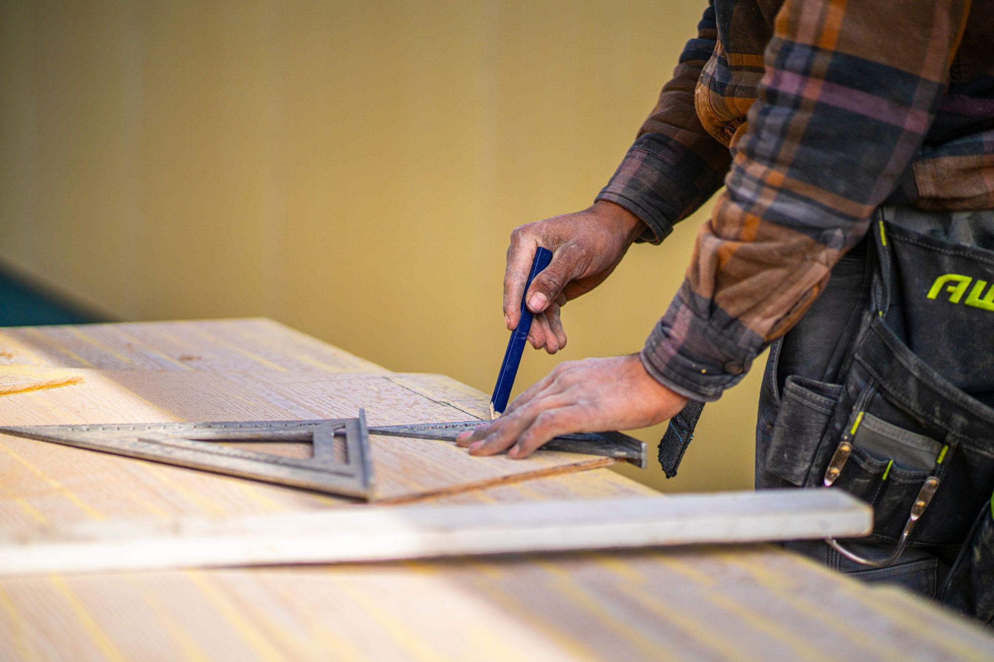 man carefully measuring a wooden board